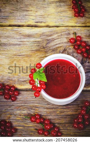 red currants jam in the white bowl on a dark wood background. toning. selective focus on leave