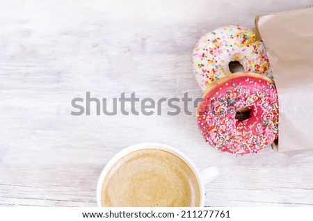 Donuts and coffee on a white wood background. toning. selective focus on red donut