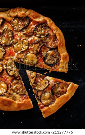 pizza with eggplant on a dark background. tinting. selective focus on a slice of pizza