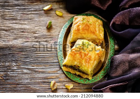 baklava with pistachio. turkish traditional delight on a dark wood background. toning