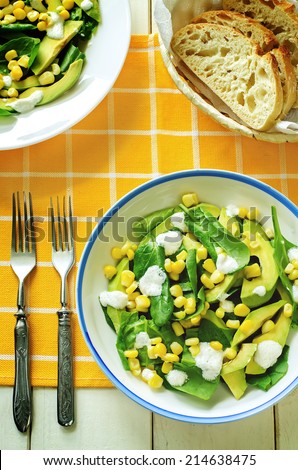 salad with corn, spinach and avocado on a yellow background. tinting. selective focus on the middle of the salad