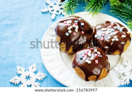 profiteroles with chocolate icing and colored powder on a blue background. tinting. selective focus on the top middle front profiteroles