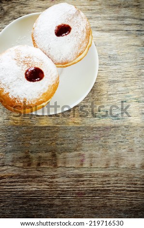 fresh doughnuts with jam on a dark wood background for Hanukkah. tinting. selective focus on the top donut