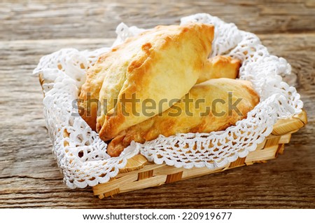 pasties stuffed meat on a dark wood background. tinting. selective focus on the front pasty