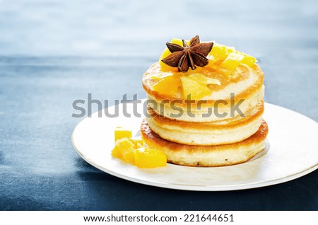 pancakes with caramelized apples on a dark background. tinting. selective focus on the star anise