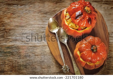 baked pumpkin stuffed with beef and vegetables on a dark wood background. tinting. selective focus on the bottom pumkin