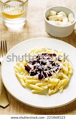 pasta with roasted beets and goat cheese on a light background. tinting. selective focus on the middle pasta