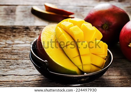 mango on a dark wood background. tinting. selective focus on the mangos slices