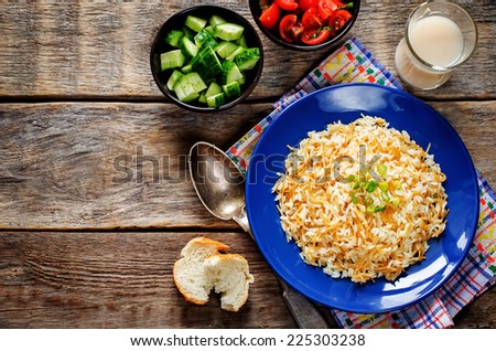 Rice with vermicelli on a dark wood background. Traditional Arabic dish. tinting. selective focus on green onions