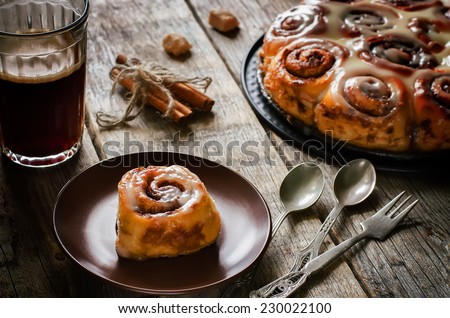 cinnamon rolls with cream icing on dark wood background. tinting. selective focus on the top of roll
