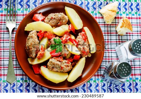 meat cutlets baked with potatoes, tomatoes and red pepper. keftesi. a Turkish dish. tinting. selective focus on parsley