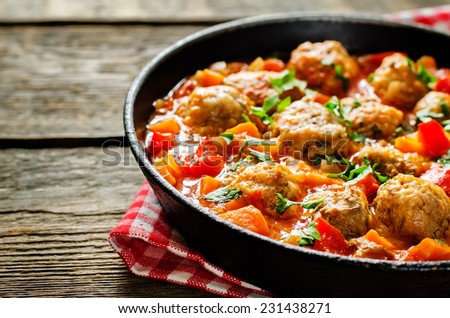 meatballs baked with vegetables on a dark wood background. tinting. selective focus