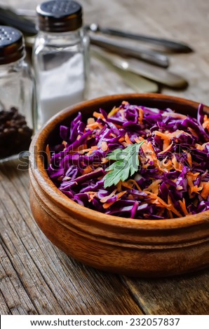 salad with carrots and red cabbage on a dark wood background. tinting. selective focus on parsley