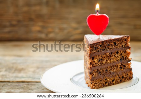 chocolate cake with candles in the shape of a heart on Valentine\'s day. tinting. selective focus