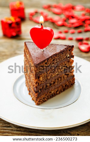 chocolate cake with candles in the shape of a heart on Valentine\'s day. tinting. selective focus