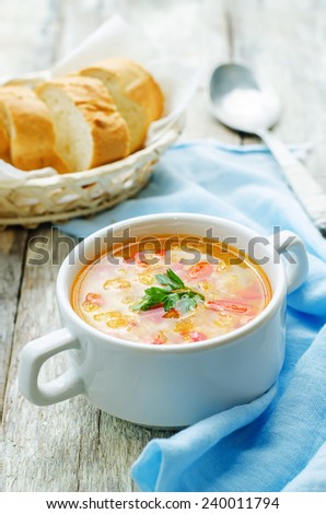 soup with salmon, potatoes and millet on a light woody background. tinting. selective focus