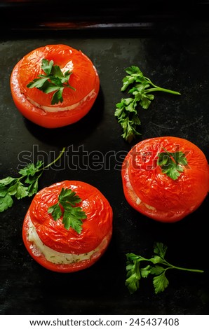 baked tomatoes stuffed fish on a dark background. tinting. selective focus