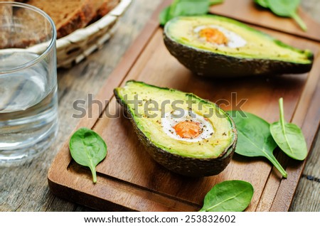 avocado baked with egg on a dark wood background. tinting. selective focus