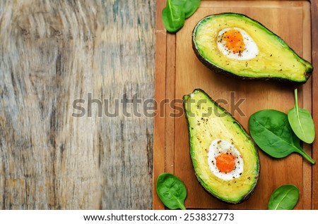avocado baked with egg on a dark wood background. tinting. selective focus