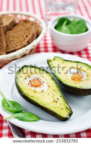 avocado baked with egg on a red background. tinting. selective focus