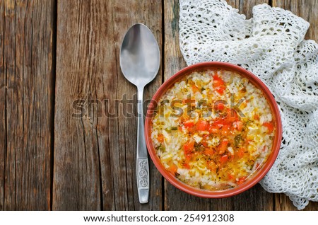 chicken soup with rice and peppers on a dark wood background. tinting. selective focus