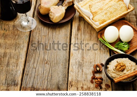 Matzah, wine, eggs, chicken, greens and haroset on a dark wood background, traditional food for the Pesach. tinting. selective focus