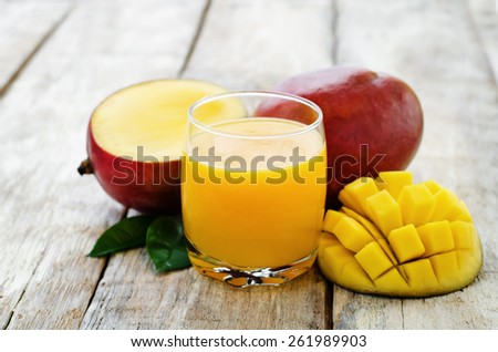 mango juice and fresh mango on a white wood background. tinting. selective focus