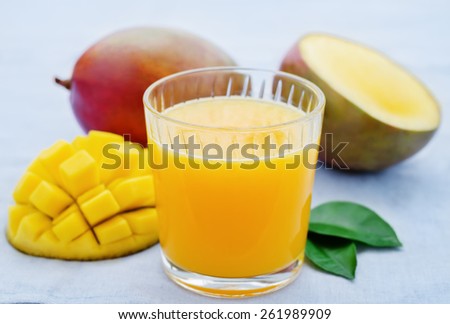 mango juice and fresh mango on a blue background. tinting. selective focus