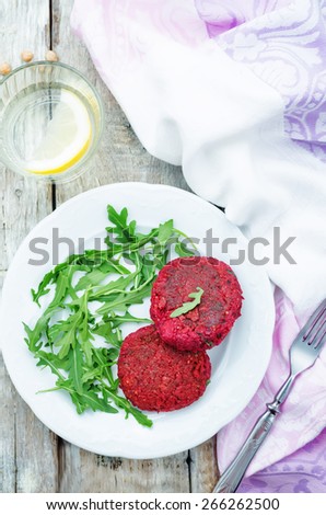 chickpeas, quinoa and beet burgers with arugula on a white wood background. tinting. selective focus