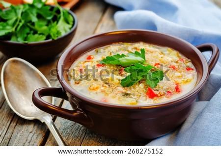 milk soup with potatoes, quinoa and peppers on a dark wood background. the toning. selective focus