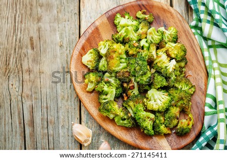 roasted broccoli with garlic on a dark wood background. the toning. selective focus