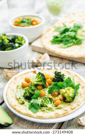 vegan tortilla with roasted broccoli and chickpeas and avocado sauce. the toning. selective focus
