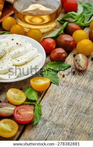 wood background with tomatoes, Basil, mozzarella, bread. toning. selective focus
