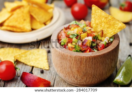 peach salsa on a dark wood background. the toning. selective focus