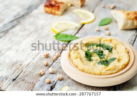 lemon hummus with Basil dressing on a dark wood background. the toning. selective focus
