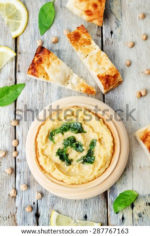 lemon hummus with Basil dressing on a dark wood background. the toning. selective focus