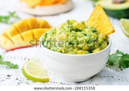 mango guacamole with corn chips on a white background. the toning. selective focus