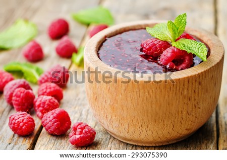 raspberry jam on a dark wood background. the toning. selective focus