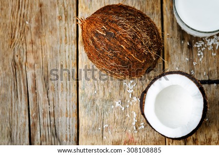 coconut and coconut milk on a dark wood background. the toning. selective focus