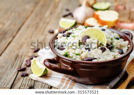 coconut lime rice with red beans and cilantro dark wood background. the toning. selective focus