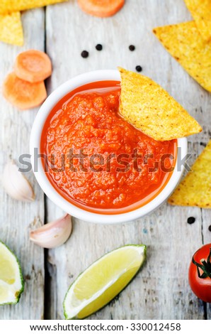blended red salsa on the white wood background. toning. selective focus