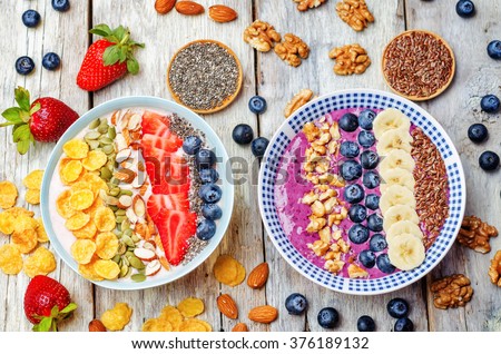 Blueberries and strawberries healthy smoothies breakfast bowls with nuts, seeds and fruits. toning. selective focus