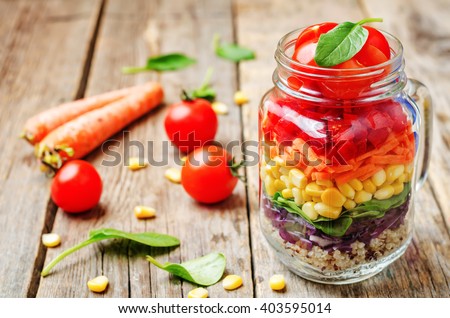 homemade rainbow salad with vegetables and quinoa on a dark wood background. toning. selective focus