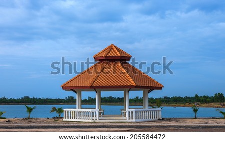 Pavilion on ground with lake and blue sky background