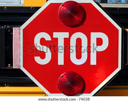 School bus stop sign on the side of the bus that flashes when the bus stops.