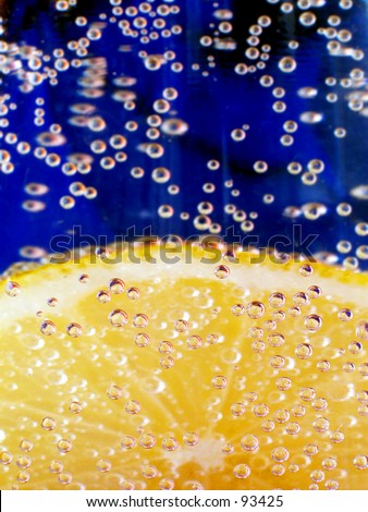 Pic number 2 of a lemon in sparkling water with a blue background.
