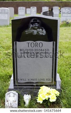 QUEENS, NEW YORK - JUNE 6: Grave of Yomo Toro, master of the Puerto Rican guitar like instrument called a cuatro.   Taken June 6, 2013 at Saint Michael\'s Cemetery in New York.