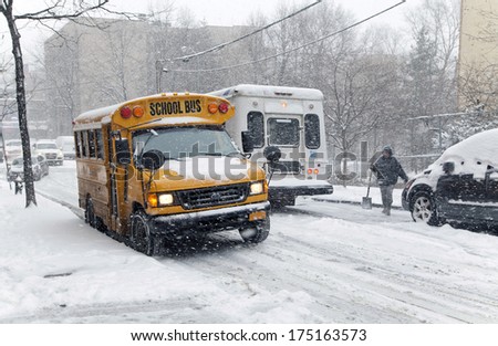 BRONX, NEW YORK - JANUARY 21: A school bus and other traffic during a 6 to 10 inch snow storm with teen temperatures along Ogden avenue and 162nd street.  Taken January  21,  2014 the Bronx, New York.