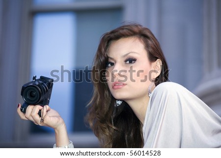 latin woman in her early twenties holding camera.  She is from Bolivia and was photographed July, 2009 in the USA.