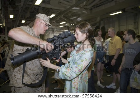 NEW YORK, NY - MAY 23: United States Marine assists a civilian holding an M224 weapon.  Photographed during Fleet Week aboard the USS Iwo Jima May 23, 2009 in NYC.